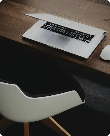 Opengeklapte laptop en muis op een houten bureau