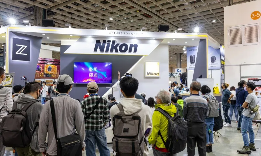 Bezoekers bij een beursstand van Nikon tijdens een vakbeurs
