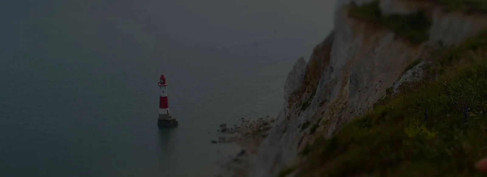 Vuurtoren aan de krijtrotsen bij zee in de schemering