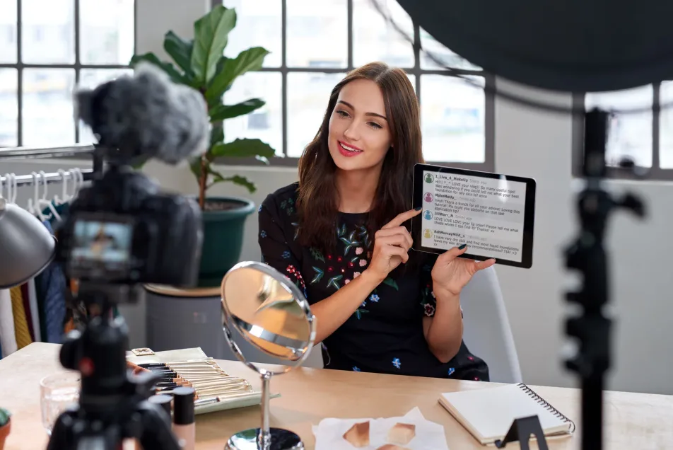 Influencer neemt video op en toont reacties op tablet tijdens contentcreatie Influencer neemt video op en toont reacties op tablet tijdens contentcreatie