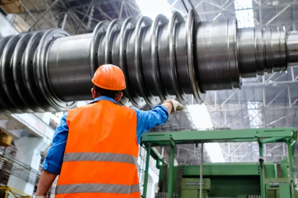Werknemer met veiligheidshesje bij industriële machine – marketing voor de maakindustrie Werknemer met veiligheidshesje bij industriële machine – marketing voor de maakindustrie