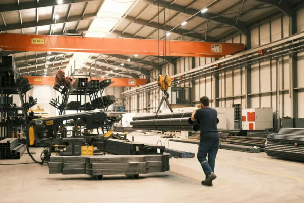Productiehal met industriële machines en werknemer – marketing voor industriële bedrijven Productiehal met industriële machines en werknemer – marketing voor industriële bedrijven